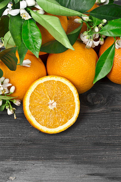 istock Fresh oranges and blossoms on a wooden surface 183851063