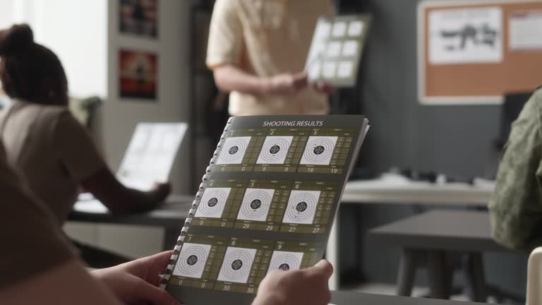 Cadet Holding Shooting Results Pamphlet During Class in College