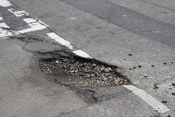 mala reparación porhole en carretera sufre un daño contra escarcha intersección en forma de t - desigual tosco fotografías e imágenes de stock