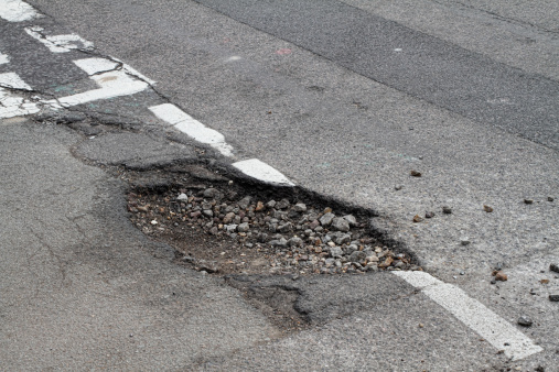 This is a T-junction in south London, and frost has done its work heaving up the surface in an area already weakened by previous road repairs. The aggregate stone beneath the surface is exposed and is scattering across the road. This sort of adverse frost action can take place place in two main ways. The first is frost heave, where ice forms below ground level and pushes the surface upwards. The second involves weakening of the substrate due to saturation of the under-surface as the ice melts.
