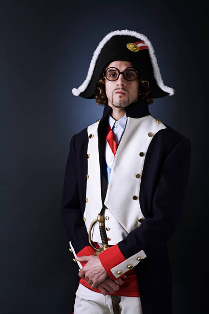 Official portrait of senior man dressed in historical emperor costume. Studio shot against dark wall.