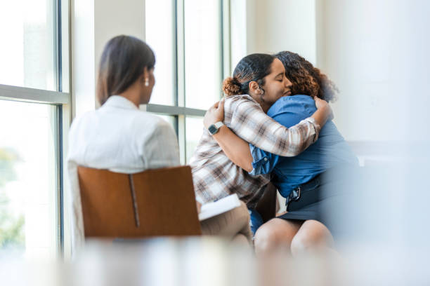 istock Two female siblings embrace one another during their grief counseling session 1838520708