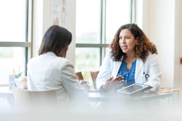 Female doctor gestures while talking to her patient