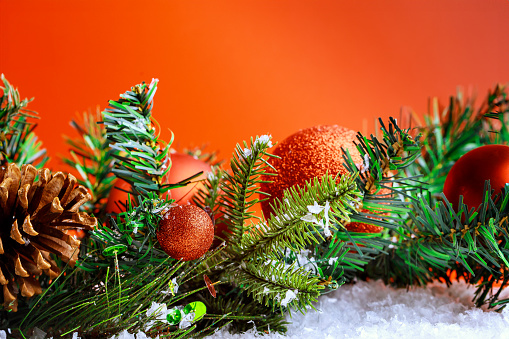 Christmas holiday fir tree branch with festive balls at red background with Happy New Year wish