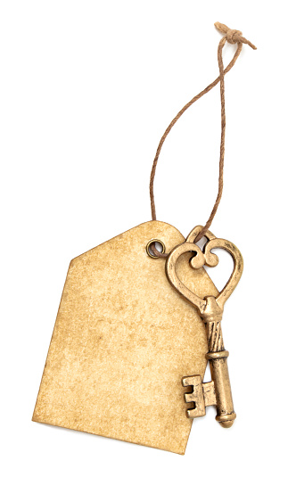 Gold key and tag on a string. Copy space on weathered tag.