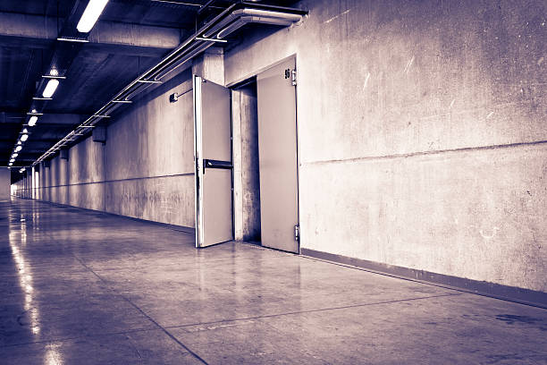 istock Long and dark corridor with open door 183854068