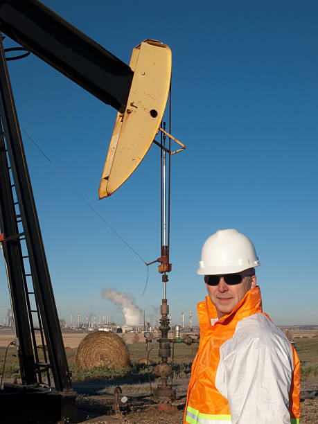 pracownik przemysłu naftowego w sprzęt bezpieczeństwa w dobrze pumpjack - engineer environment factory orange zdjęcia i obrazy z banku zdjęć