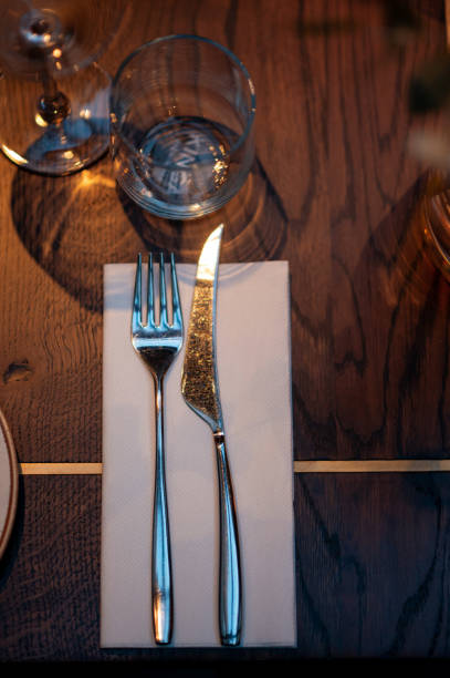 istock Table setting in restaurant. Fork and knife on the table with napkin. 1838549600