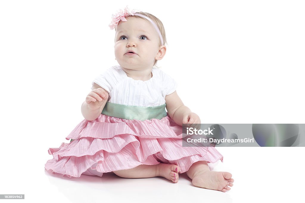 Baby Girl Wearing Dress and Sitting on White Background "Baby girl, 11 months old and wearing dress, sitting on white background." 12-23 Months Stock Photo