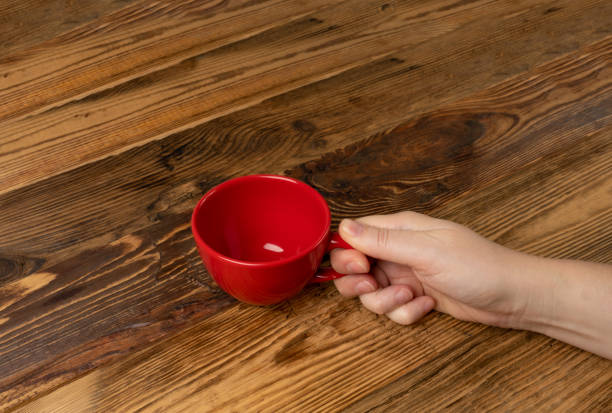 istock Hand Holds Cup, Empty Red Cup in Hands, Coffee Mug, Teacup, Hot Beverage Mockup 1838553291