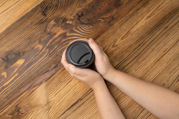 istock Hand Holds Cup, Empty Paper Cup in Hands, Coffee Mug, Teacup, Hot Beverage Mockup, Cup in Arms 1838553294