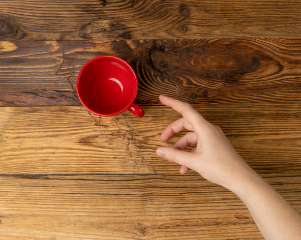 istock Hand Holds Cup, Empty Red Cup in Hands, Coffee Mug, Teacup, Hot Beverage Mockup 1838553300