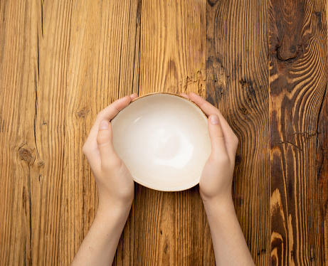 Bowl in Hands, Empty Bowl in Arms on Wooden Background, Vintage Kitchen Tableware Mockup, Dishware Banner, Empty Plate, Starving, Hungry Concept, Ceramic Bowl with Copy Space for Text