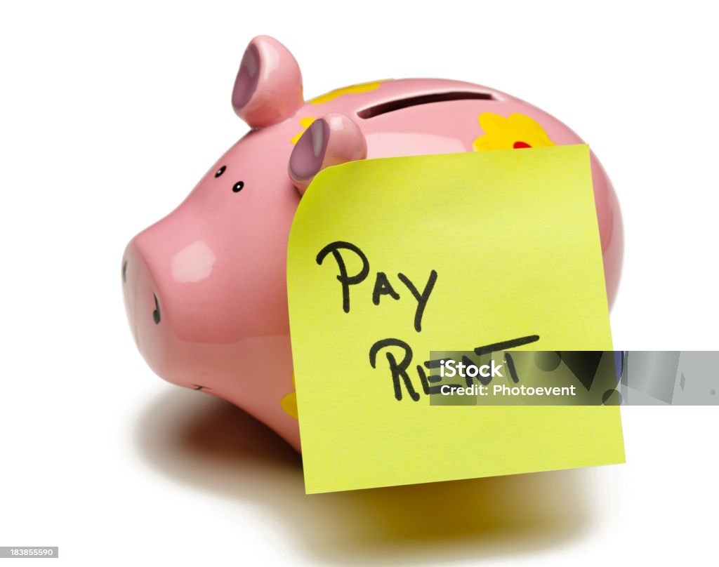 A pink piggybank with pay rent  written on it Pay rent note on Piggy Bank. Isolated ob white Adhesive Note Stock Photo