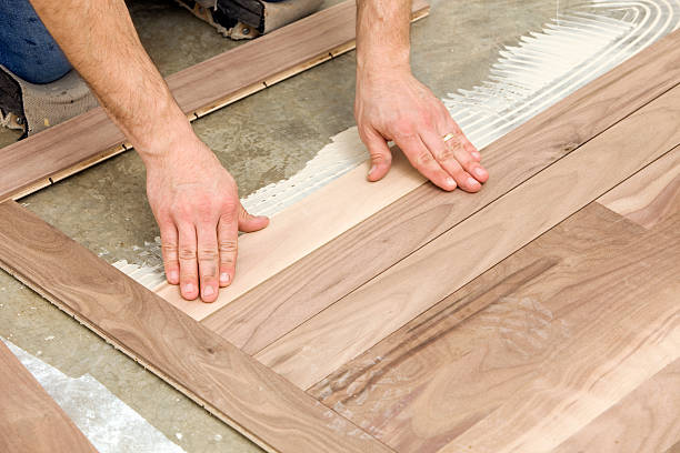 istock Worker Installing Walnut Hardwood Floor over Concrete 183855613