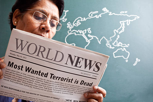 india senior mujer leyendo las noticias del mundo sobre terroristas más quería - newspaper good news the media announcement message fotografías e imágenes de stock