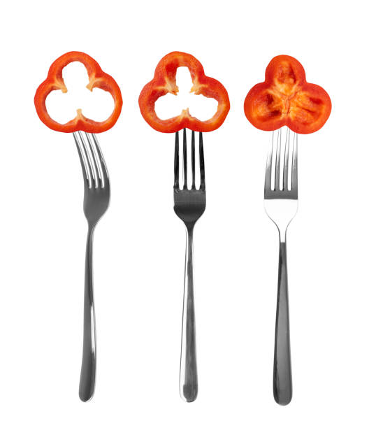 Paprika or red sweet pepper on forks isolated on white background. Bell pepper or bulgarian pepper collection