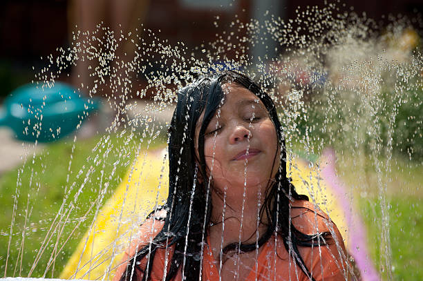 istock One little girls playing with water in the frontyard 183857535