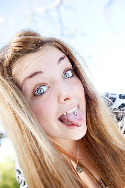 teen ragazza mettere fuori la lingua con clip a - pierced human tongue tongue stud teenager foto e immagini stock