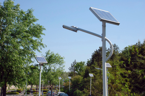 Pole mounted with solar panels and lights led illuminating.