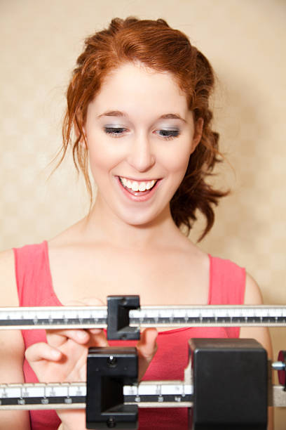 Happy Young Woman on a Weight Scale.See more of this model: