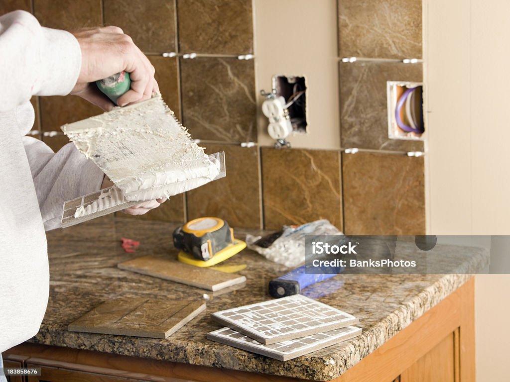 Trabajador Troweling Morter en azulejos de cocina nueva Backsplash - Foto de stock de Cocina - Estructura de edificio libre de derechos