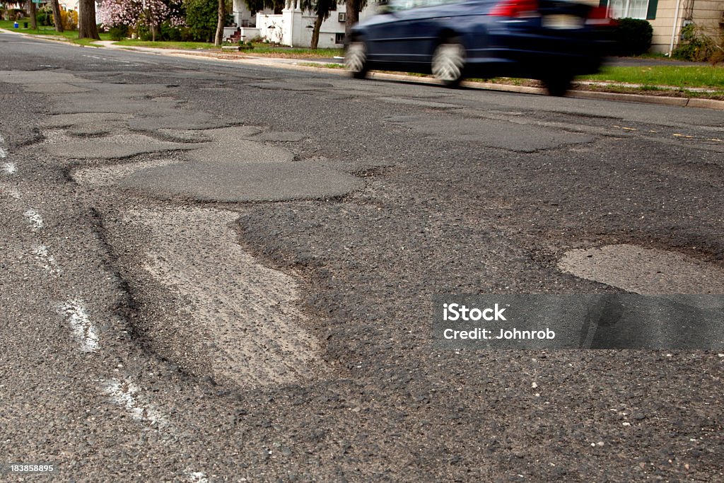 Sévèrement potholed suburban road, gros plan de potholes - Photo de Route libre de droits