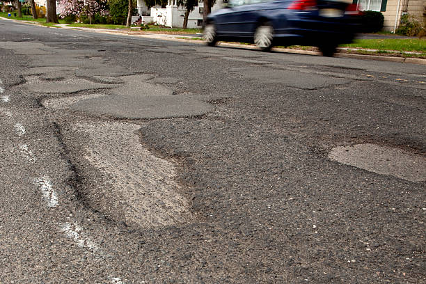 郊外 road に向かって駆動する potholed 、クローズアップの potholes - bumpy ストックフォトと画像