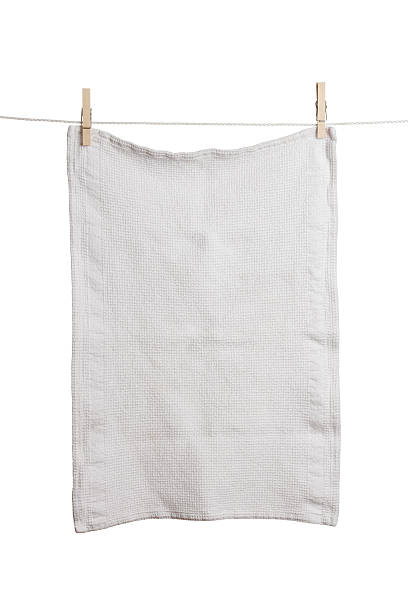 A plain white dish towel hanging on a line stock photo