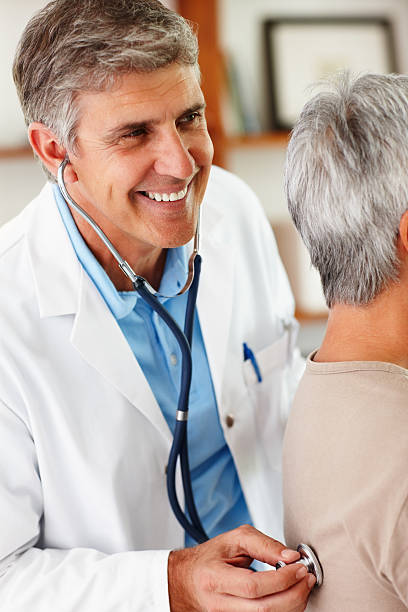 istock Smiling middle aged Doctor examining a patient 183859638