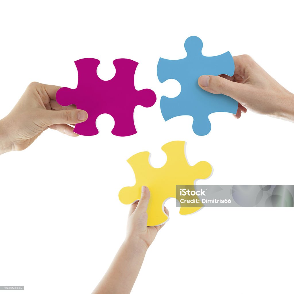 Hands Holding Colored Puzzle Pieces "Three hands -male, female and child- holding big colored puzzle pieces -magenta, cyan and yellow- on white background. Two clipping paths included one for the puzzle surface and one for the background.Same pictures with different colors:" Three Objects Stock Photo