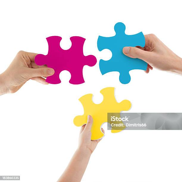 Hands Holding Colored Puzzle Pieces Stock Photo - Download Image Now - Three Objects, Three People, Jigsaw Piece