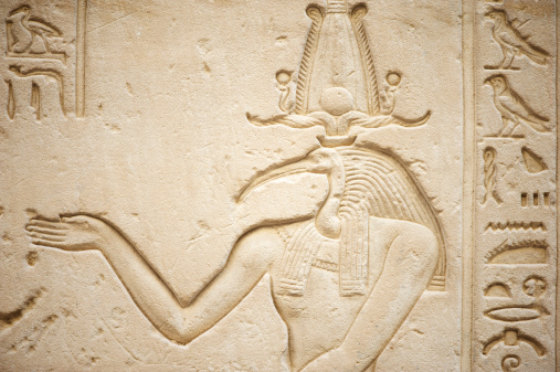 Ancient Egyptian hierogliph of Thoth an ibis-headed god surrounded by other well-demarcated hieroglyphs on a light stone wall at the Temple of Horus in Edfu
