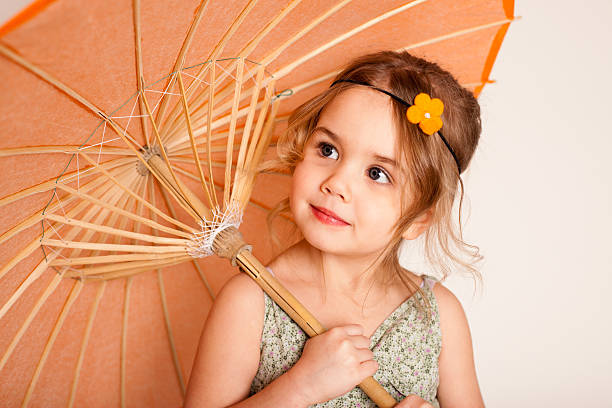 Color image of a little girl holding an umbrella.