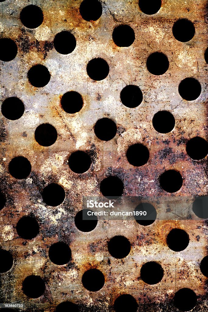 Rusty Metal Holes A sheet of scrap metal with holes drilled into it Abstract Stock Photo
