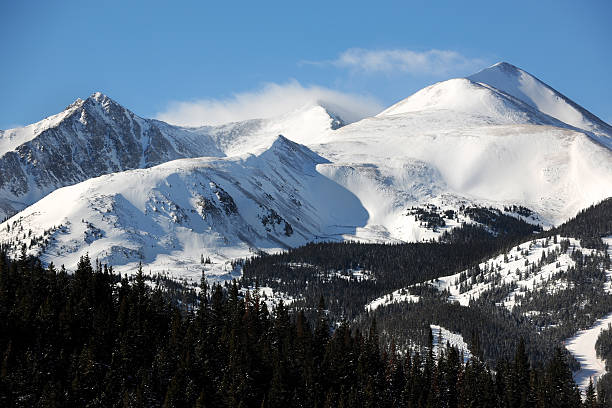 Clouds Blowing Across Snowy Mountain Range "Snowcapped mountains rising above pine forests at Ten Mile Range, Colorado." tenmile range stock pictures, royalty-free photos & images