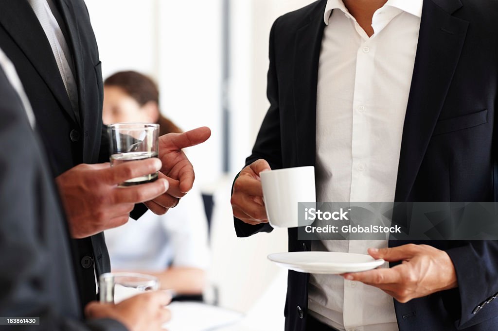 Business people having water and coffee Cropped view of business people with glass of water and cup of coffee Adult Stock Photo