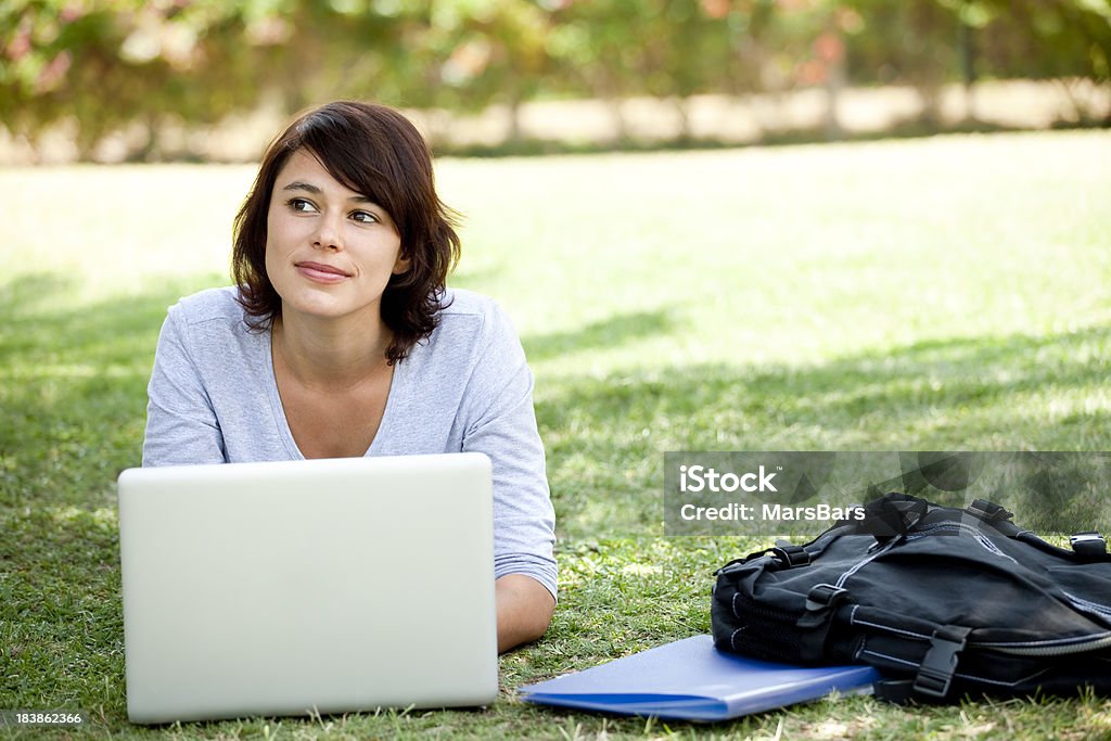 Étudiante pensant tout en utilisant un ordinateur portable - Photo de Ordinateur portable libre de droits