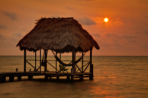 A palapa hut at sunrise on the caribbean island of Caye Caulker in Belize.