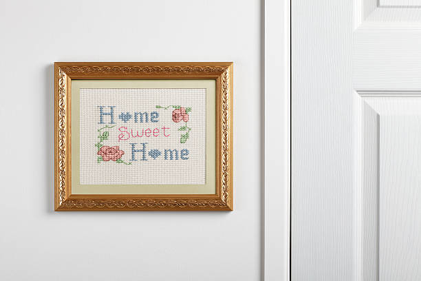 Home Sweet Home sampler hanging on a wall A Home Sweet Home sampler hanging on a wall. embroidery photos stock pictures, royalty-free photos & images