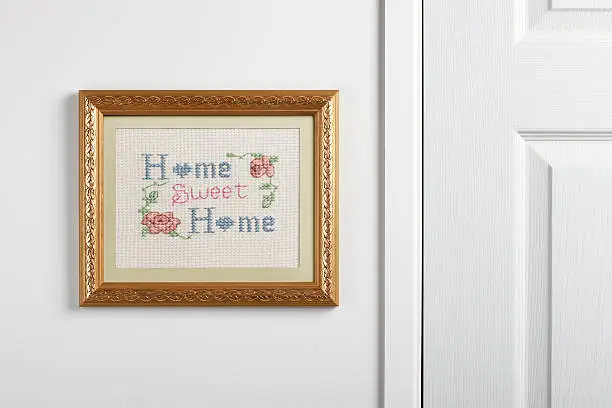 A Home Sweet Home sampler hanging on a wall.