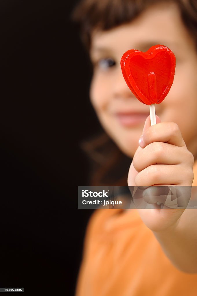 Bambino con un cuore di Lecca-lecca rosso - Foto stock royalty-free di Bambino