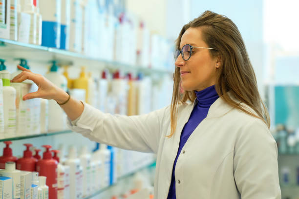 istock Young long-haired pharmacist in profile placing products on the shelf in a pharmacy 1838631848