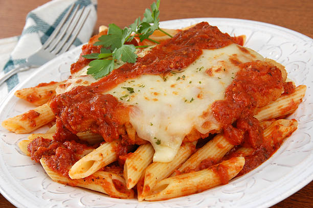 Chicken Parmigiana Italian comfort food - chicken parmigiana served on top of pasta with marinara sauce.More images of chicken parmigiana and eggplant parmigiana: marinara stock pictures, royalty-free photos & images