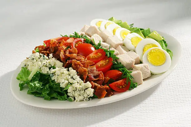 "Traditional Cobb salad of romaine lettuce, Roquefort cheese, bacon, tomatoes, chives, boiled chicken, hard boiled eggs and avocado."