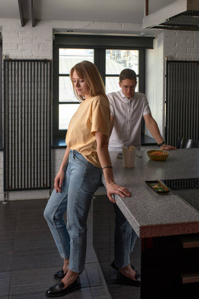 Young couple ignoring each other after having argument in kitchen
