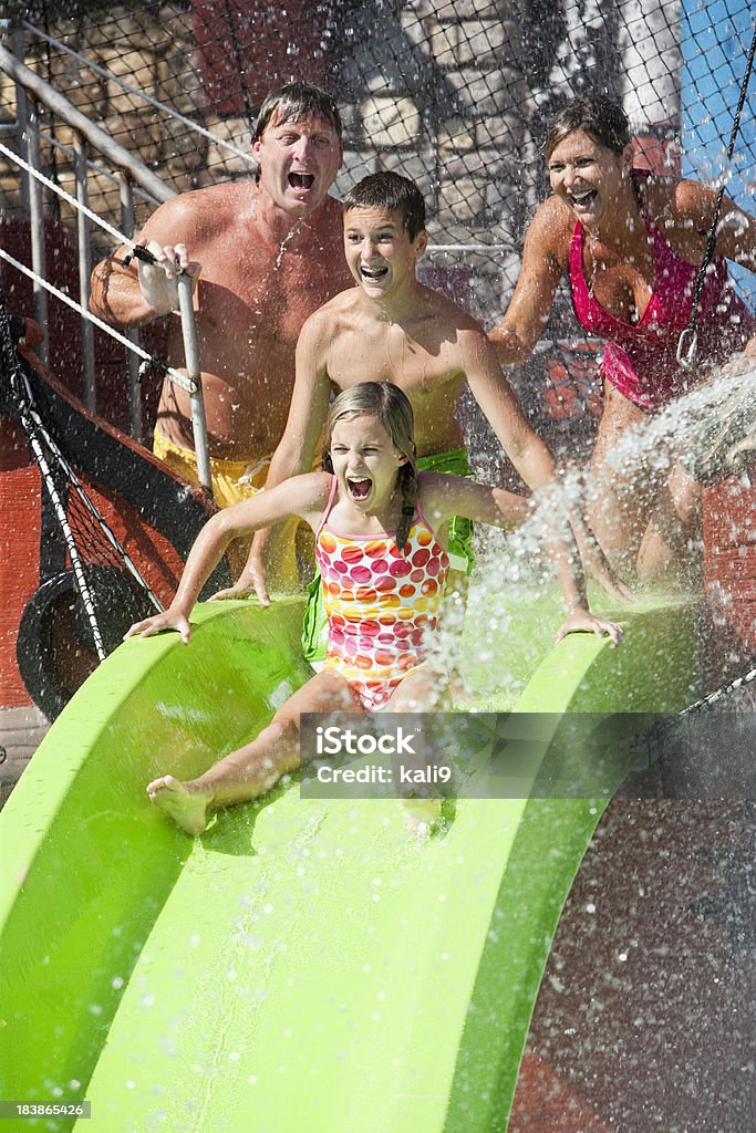 Família com Garota descendo lá Slides no parque aquático - Foto de stock de Criança royalty-free