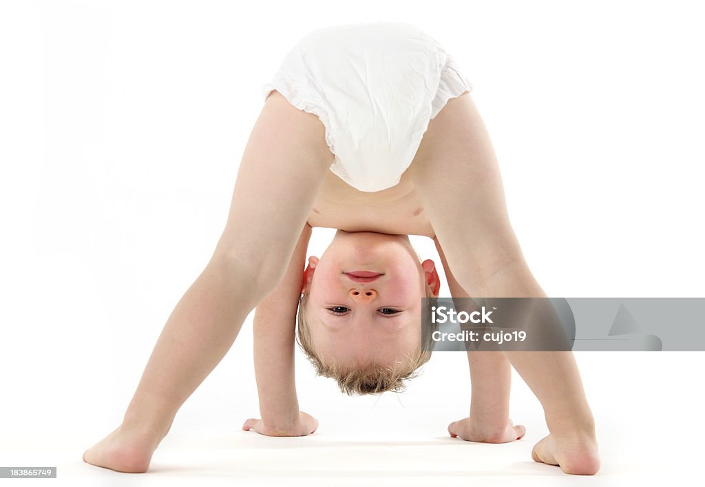 Upsidedown Play "Little boy playing , looking upsidedown through his legs." Diaper Stock Photo