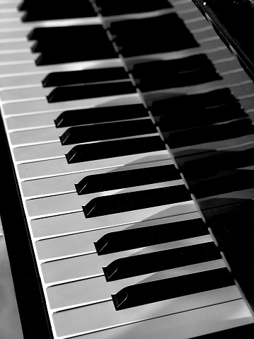Close up artistic black and white photo of grand piano keys