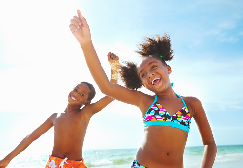 Boy and girl smiling while dancing on the beach